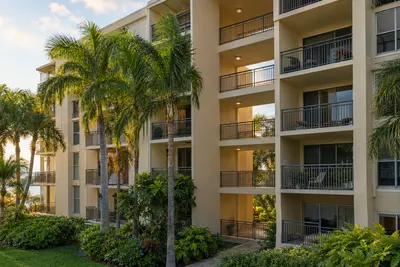 Balconies on a South Florida condo building surrounded by palms in late afternoon light